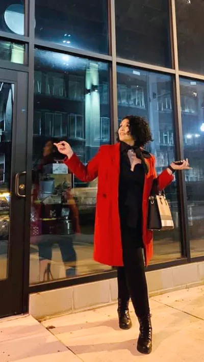 Gabrielle in Red Coat outside store while under construction.